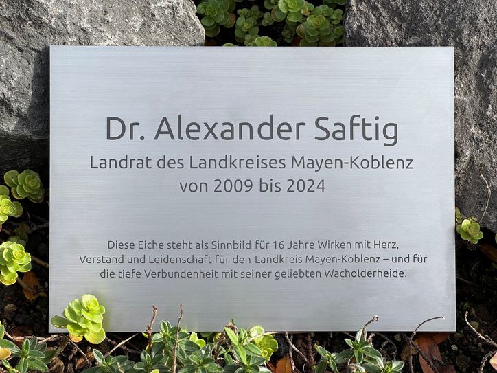 Merklich stolz war Dr. Saftig zudem auf die Inschrift der Plakette (links), die auf sein Wirken in MYK aufmerksam macht und demnächst unmittelbar vor der Eiche angebracht wird.