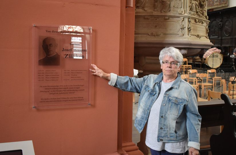 "Erinnern darf nicht aufhören" - Monika Rolef vor der Gedenktafel für Pfarrer Zilliken in der Basilika Prüm.