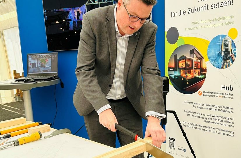 Griff am Ausbildungstag bei der Euregio Wirtschaftsschau zur Säge: Städteregionsrat Dr. Tim Grüttemeier.