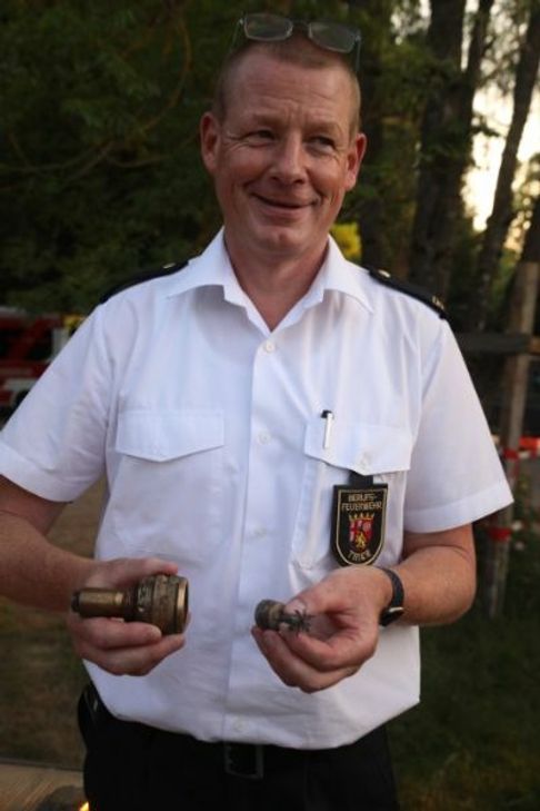 Gelöste Stimmung nach der Entschärfung: Triers Feuerwehrchef Andreas Kirchartz präsentiert die herausmontierte Zündvorrichtung der Weltkriegsbombe. Foto: Presseamt Trier