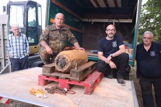 Marco Ofenstein (2.v.r.) und sein Team vom Kampfmittelräumdienst Rheinland-Pfalz mit der Bombe, die sie in nur 26 Minuten entschärfen konnten. Foto: Presseamt Trier