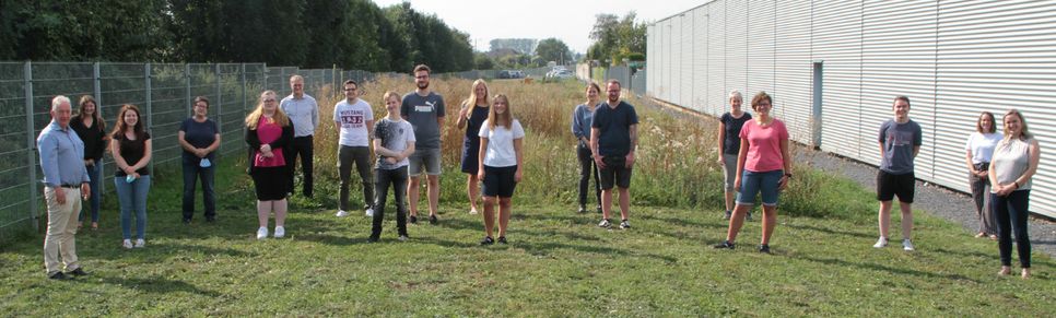 Die neuen Azubis, ihre Mentoren und die Geschäftsführer Georg Richerzhagen (6.v.l), Winfried Fiege (1.v.l.) sowie Tanja Scheuls (rechts), Geschäftsfeldleitung Bildung und Berufliche Integrationsdienste, stellten sich vor dem gemeinsamen Grillnachmittag zum Gruppenfoto auf. Foto: Michael Thalken/Eifeler Presse Agentur/epa