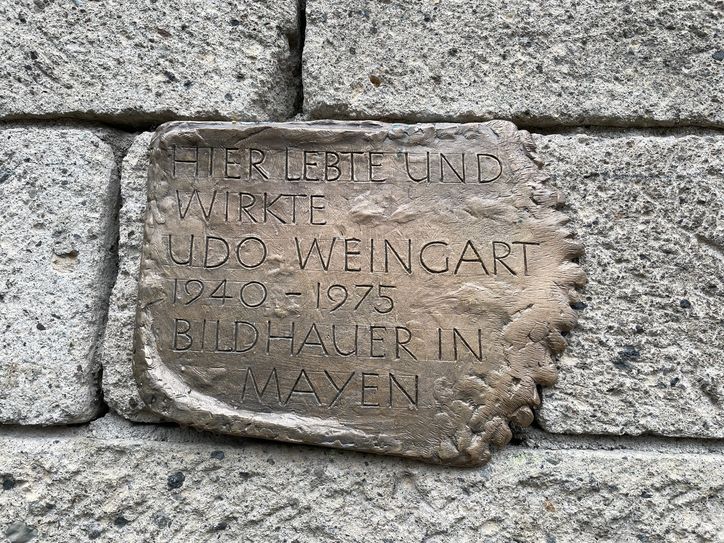 Inschrift: »Hier lebte und wirkte Udo Weingart 1940-1975 Bildhauer in Mayen«.