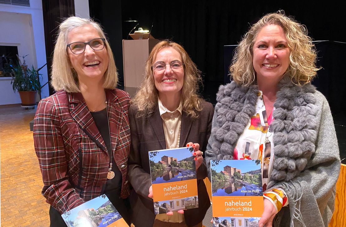 Präsentieren das frisch gedruckte "Naheland-Jahrbuch 2024" (v. l.): Sandra Ess, Redaktionsleiterin Dr. Christa Schneider von Lehmden und Landrätin Bettina Dickes.