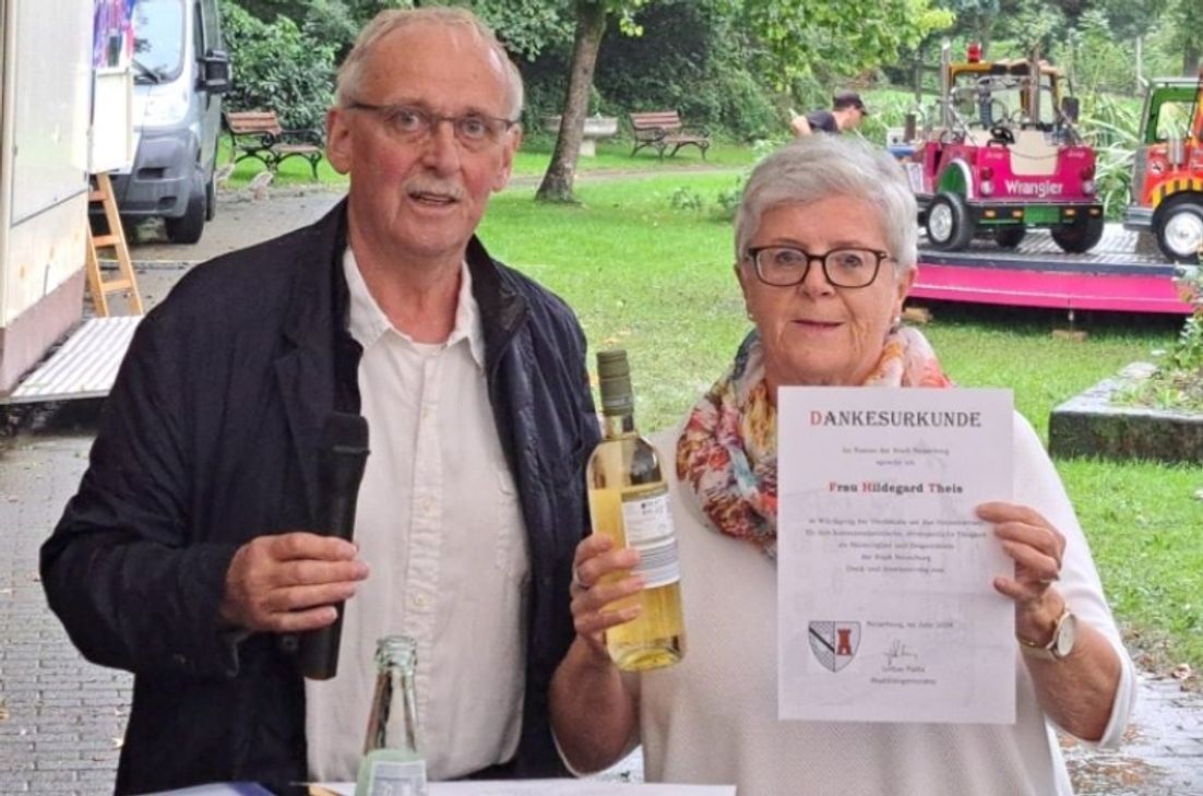Hilla Theis wird für ihre 15-jährige Tätigkeit im Stadtrat von Neuerburg ausgezeichnet. Bürgermeister Lothar Fallis überreicht ihr eine Urkunde und ein Präsent als Anerkennung für ihr Engagement.