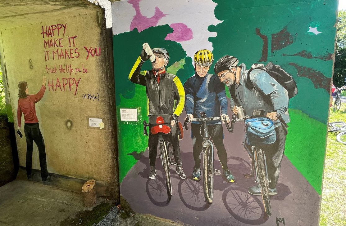 In der "Freilichtgalerie" direkt am Kyll-Radweg hat Monica Breuer auch eine Radfahrergruppe auf dem "Kyllradweg" porträtiert, die an der "Freilichtgalerie" gehalten hatten.