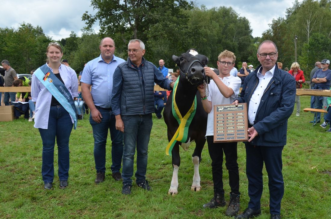 Stolz präsentiert Familie Krämer (alle in weißen Oberteilen) ihre Gewinnerkuh Sonia. Ebenfalls auf dem Foto: Milchkönigin Klara Scholtes (links) der Keller Ortsbürgermeister Markus Lehnen (3. von links) VG-Chef Jürgen Dixius und Landrat Stefan Metzdorf (4. und 2. von rechts.) sowie Preisrichter Nico Billen aus Kaschenbach (2. von links). Foto: Fischer