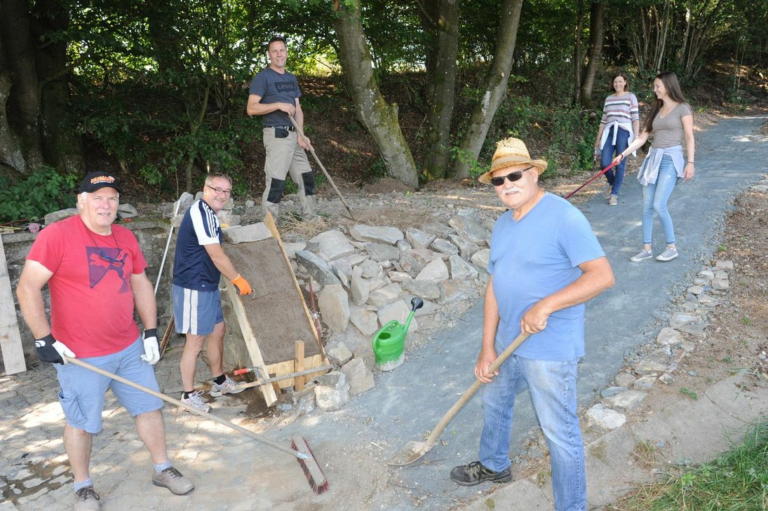Reinsfelder um Paul Port (vorne) bei einem ihrer Arbeitseinsätze. Die neu geschaffene Anbindung eines beliebten Wanderweges wird rege genutzt, wie beim Fototermin zufällig vorbeigehende Spaziergänger bewiesen. Foto: Schmieder