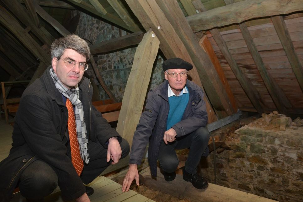 Unter dem Dach zeigen Pfarrer Wolfgang Köhne (r.) und Prof. Dr. Dr. Georg Schuppener vom Presbyterium die Schäden an den Balken des Roetgener Gotteshauses auf.