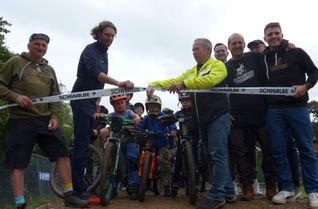 Der erste Vorsitzende, Norbert Wirtz, schneidet im Beisein begeisterter junger Radsportler und Mitstreiter das Band zum neuen »Dirt Parc« durch.