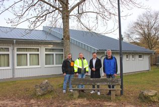 Frisch saniert: Manfred Schlierf aus dem Vorstand des Bürgervereins, Bürgermeister Emmanuel Kunz, Projektleiter Stefan Etten sowie Ortsvorsteher Brian Linden vor dem neuen Anbau der Sistiger Bürgerhalle.