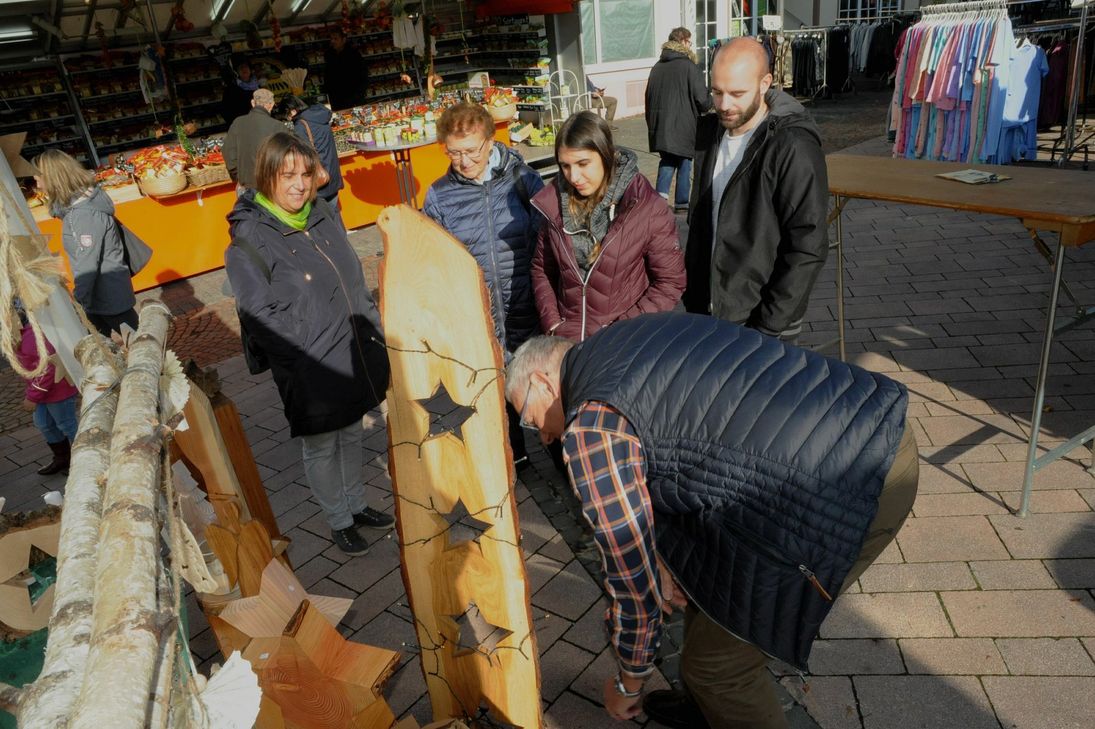 Die Lichterkette, die Kurt Huwer hier befestigt, setzt das von ihm angefertigte vorweihnachtliche Holzobjekt perfekt in Szene.