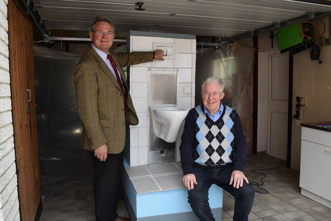 Landrat Günter Rosenke ließ es sich als gelernter Techniker nicht nehmen, den von Heinrich Meier selbst entwickelten Proto-Typen des elektrisch höhenverstellbaren Wand-WC in Augenschein zu nehmen. Foto: Breuer