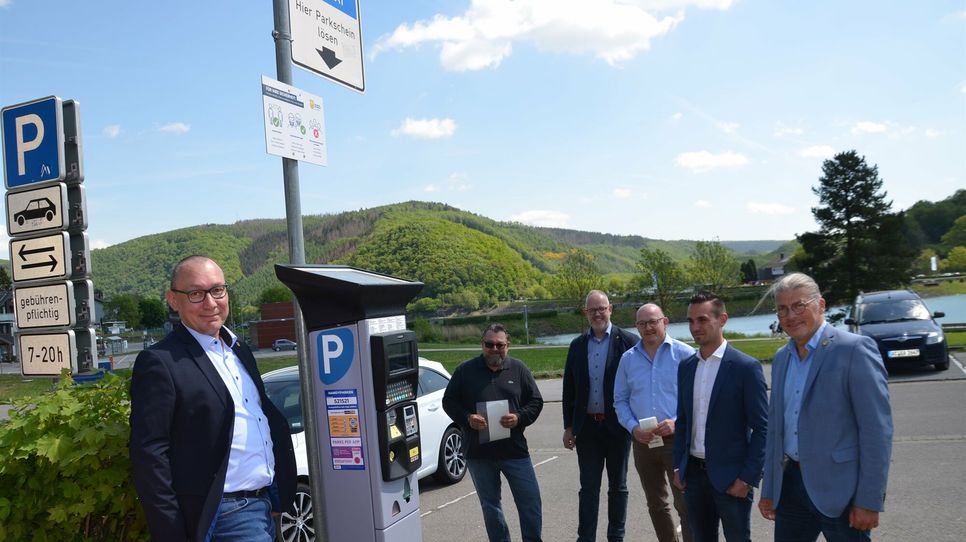 Vertreter der Gemeinde Simmerath und der beiden App-Anbieter statten die Park-Automaten am Rursee mit der App-Funktion aus.