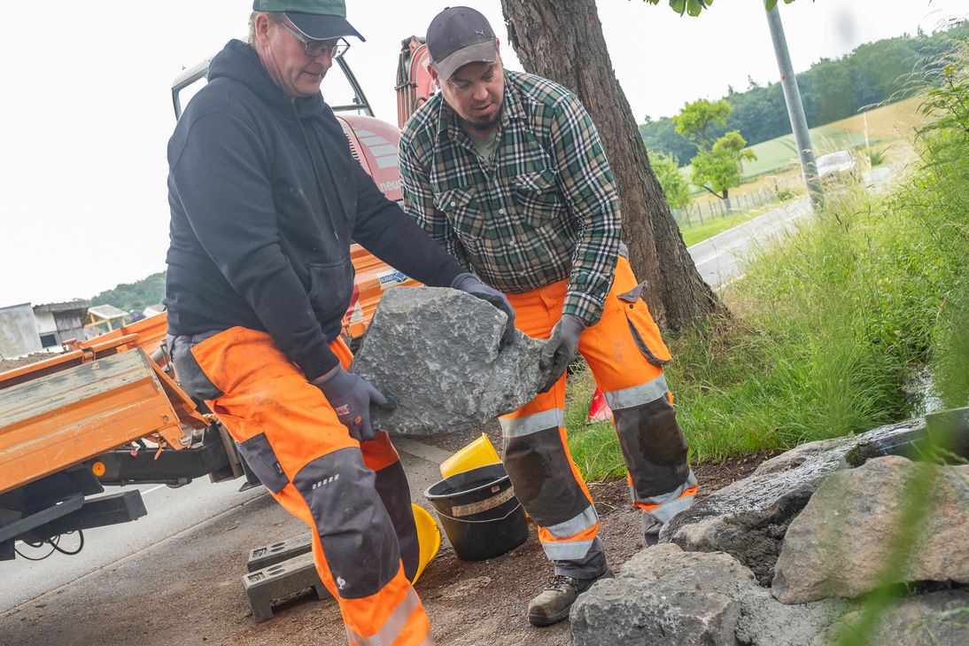 Mit schweren Natursteinen haben der stellvertretende Bauhofleiter Alexander Schröder (r.) und sein Kollege Marcel May heute die Quelle zugemauert.