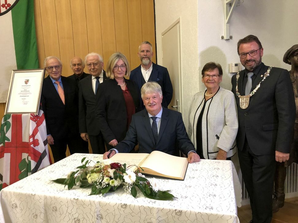 Als neuer Ehrenbürger Mayens durfte sich Rolf Schuhmacher (Mitte, sitzend) in das Goldene Buch der Stadt eintragen.                                                                                                                                                                                   Foto/Video: Wicher