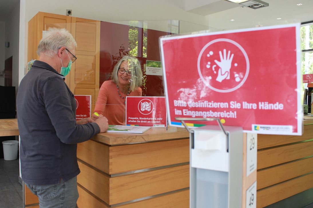 Ein Bild, dass man in Zeiten von Corona kennt: Veränderte Abläufe, Desinfektionsmittel und Regelungen zum Abstand ermöglichen wie hier im Nationalpark-Tor Heimbach ab sofort wieder touristische Beratung. Foto: Nationalparkverwaltung Eifel/M. Weisgerber