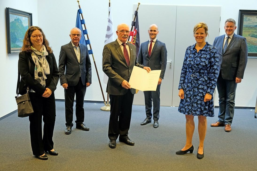 Landrätin Julia Gieseking (2.v.r.) überreichte Ewald Adams (3.v.l.) die Ehrenurkunde. Anita Adams (v.l.), Rainer Berlingen, Thomas Scheppe und Gordon Schnieder gratulierten.