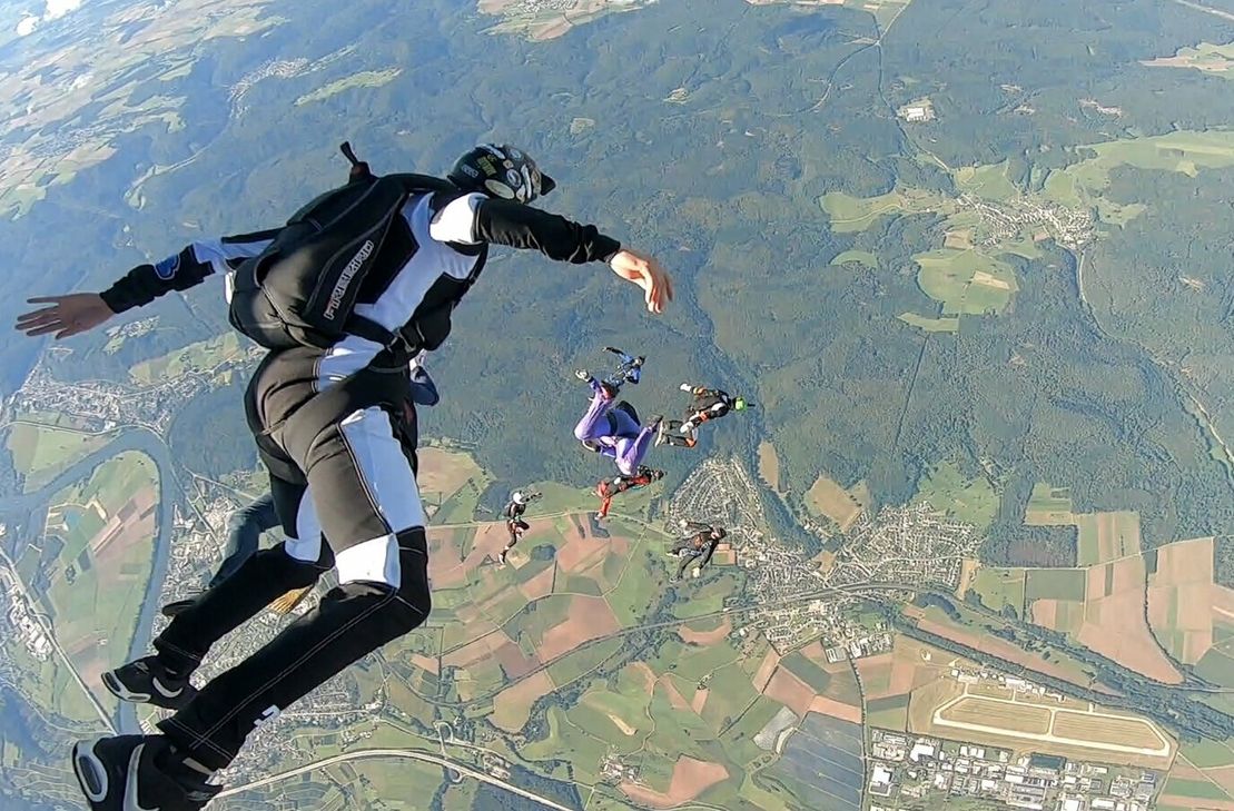 Gruppe von Springern beim Absprung aus 4000 Metern Höhe über dem Flugplatz in Föhren.