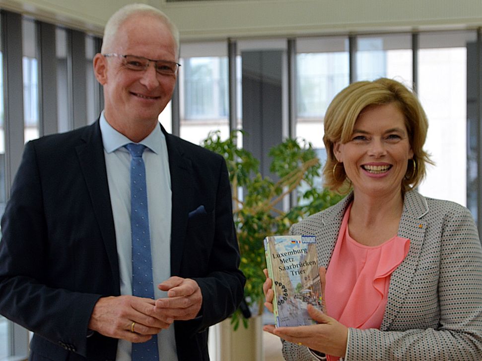 OB Wolfram Leibe überreicht Schirmherrin Julia Klöckner den ersten grenzüberschreitenden Reiseführer für die Städte der Quattropole. Foto: Finkenberg