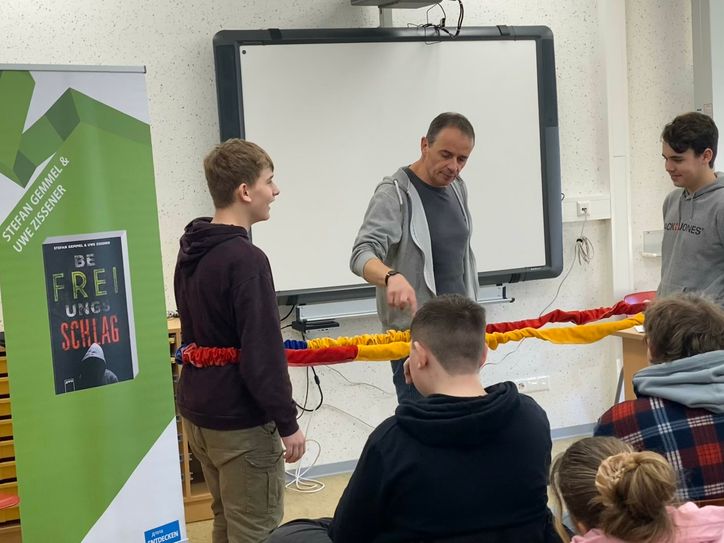 Autor Stefan Gemmel gestaltet seine Lesungen interaktiv, indem er Inhalte aus seinen Roman „Befreiungsschlag“ mit Schülerübungen nachstellt.