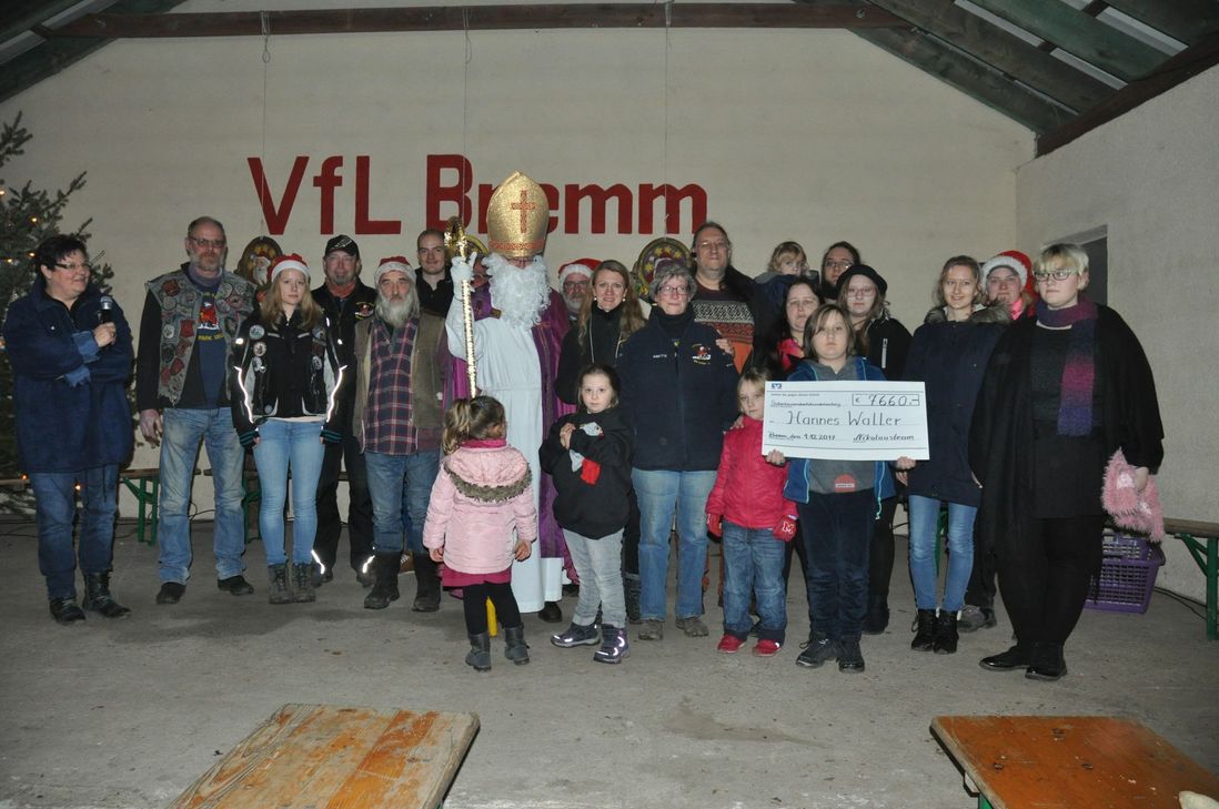 Gruppenbild mit Spendenscheck und Nikolaus: Das Nikolaus-Team konnte in den vergangenen zwölf Monaten 7.660 Euro für den kleinen Hannes Waller aus Pünderich sammeln. Die Spendensumme wurde von der Familie des Jungen entgegengenommen.