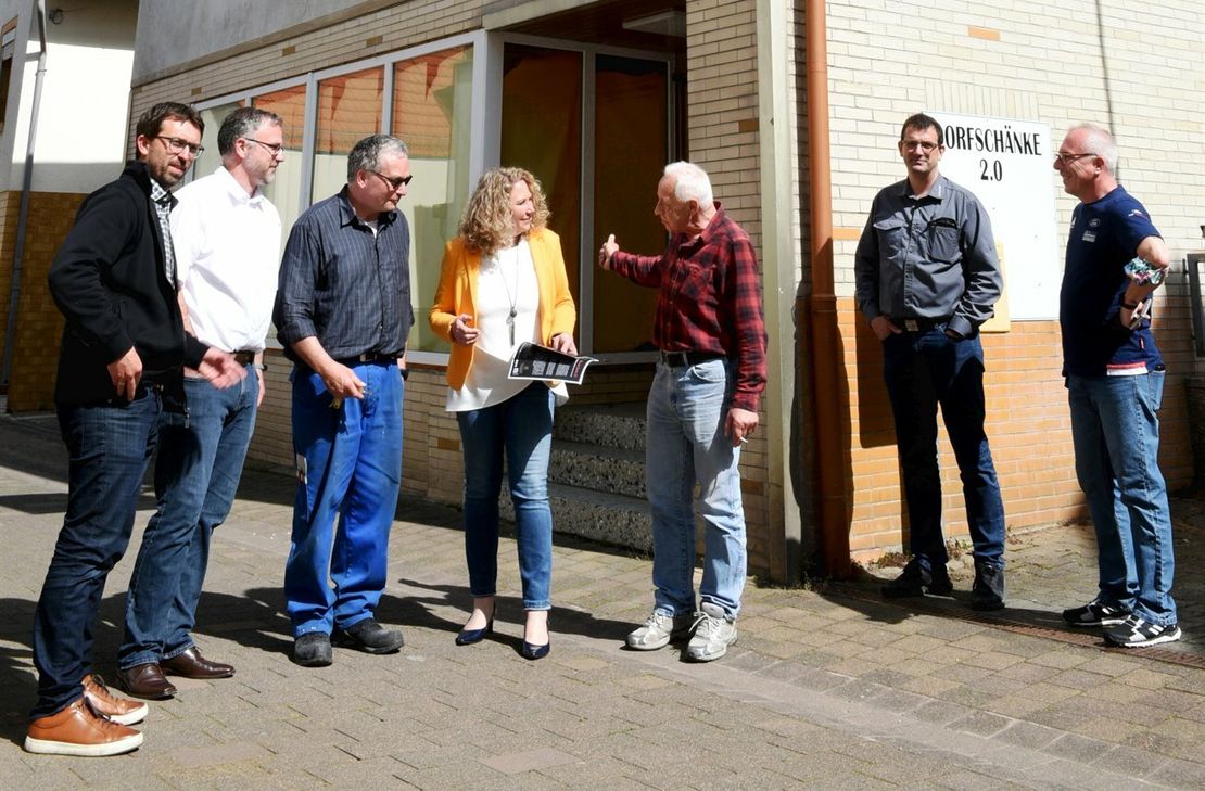 Ortsbürgermeister Johann Klein, Landrätin Bettina Dickes, Tante-M-Gründer Christian Maresch und einige Ratsmitglieder sehen sich das leerstehende Ladenlokal in der Schulstraße 25 an, in  das der Tante-M-Laden einziehen soll.