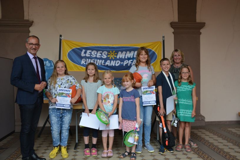 Bürgermeister Weber (links), Bibliotheksleiterin Kurzmann (hinten rechts) und die sieben Gewinner des Lesesommers. Foto: VG Konz