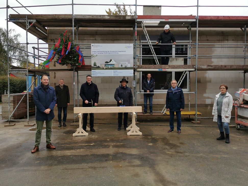 Der 1. stv. Bürgermeister von Monschau, Georg Kaulen (vorne links), und Städteregionsrat Dr. Tim Grüttemeier (vorne, rechts) konnten zum Richtfest der Erweiterung der Kindertagesstätte in Imgenbroich an der alten Grundschule jetzt die traditionellen letzten Nägel einschlagen. Schon im Herbst 2021 soll die Kita bezugsfertig sein. Foto: Breuer