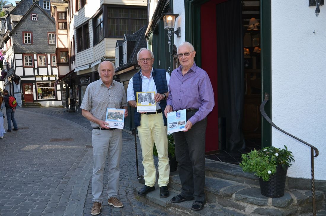 Am »Dicken Stein« auf dem Marktplatz, wo einst eine Gaststätte war und heute wieder ist, präsentieren Franz Wilhelm Hermanns, Hilmar Weber und Manfred Brandenburg den Kalender »Gruß aus Montjoie«