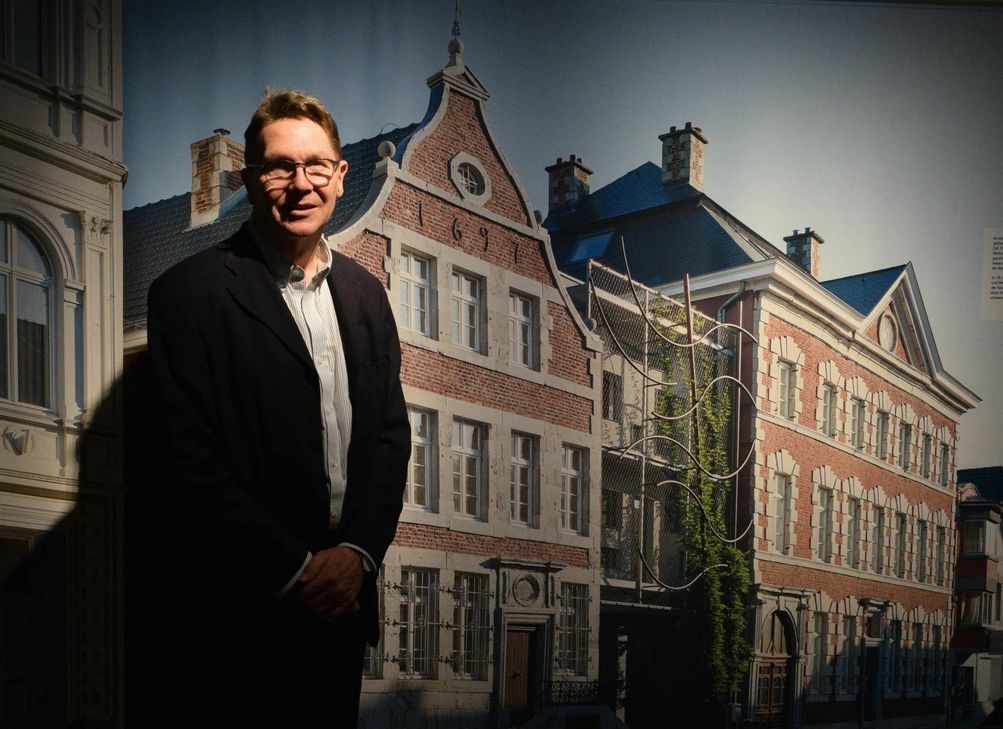 Detlef Stender, Leiter des LVR-Industriemuseums Tuchfabrik Müller in Kuchenheim vor einer Fotografie von den Tuchkaufmannshäusern in Eupen. Foto: Amelie Flaig