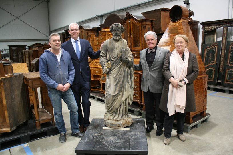 Steinmetzmeister Henning Wirtz, der die Skulptur restaurieren wird und Oberbürgermeister Wolfram Leibe nehmen den Stadtpatron in Empfang. Karl-Heinz Scheurer, Vorsitzender der Trier-Gesellschaft und Dr. Elisabeth Dühr, Direktorin des Stadtmuseums Simeonstift, finanzieren die Arbeit des Steinmetzen. Foto: Stadtmuseum Simeonstift Trier