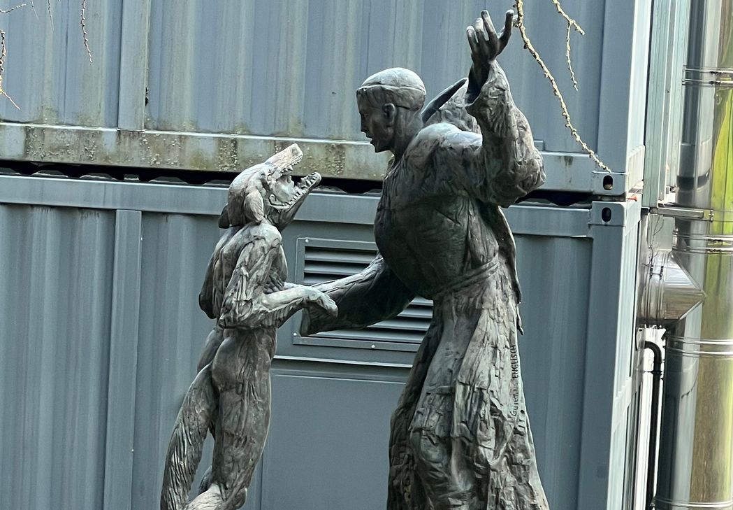 Der Heilige Franz von Assisi zähmte einst einen Wolf und brachte ihn mit den Menschen zusammen- Pater Laurentius hat das in dieser Skulptur am Vossenacker Franziskusweg dargestellt. Auch die Aufarbeitung der Missbrauchsstudie lebt von Anklage, Verständnis und Begleitung.