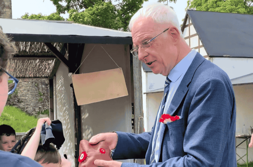 Ein Kind präsentiert OB Wolfram Leibe stolz seinen selbstgenähten Geldbeutel.