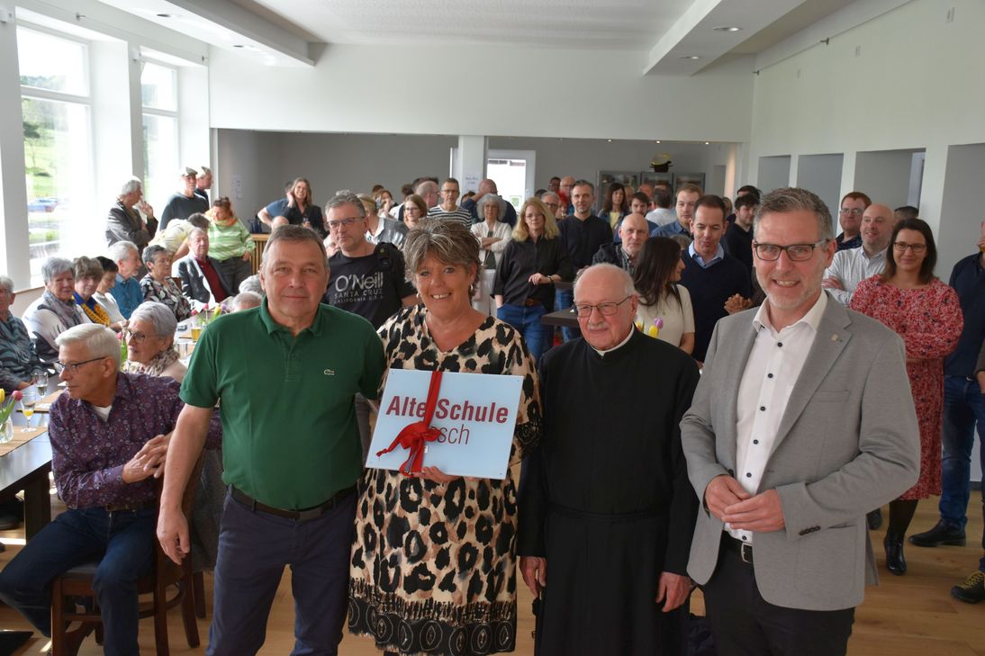 Jürgen Prinz (v.li.), Sprecher der freiwilligen Helfer, und Ortsvorsteherin Daniela Nielen freuten sich über das Schild  »Alte Schule Pesch«, das Bürgermeister Norbert Crump (re.) als Präsent überreichte. Pater Hermann Preußner (2.v.re.) segnete das Gebäude ein.