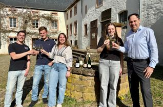 (v.l.): Die jungen Winzer Christof Schuster, Fabian Schafhausen, Vanessa Reuter, Lena Hein und Bürgermeister Guido Wacht laden Sie ins Freilichtmuseum Roscheider Hof zum „WeinGenuss 2026“ ein.