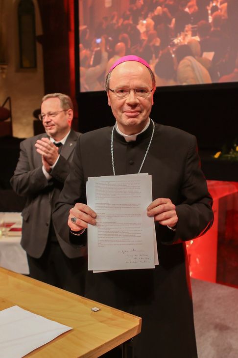 Bischof Ackermann mit den Abschlusspapieren. Foto: Bistum