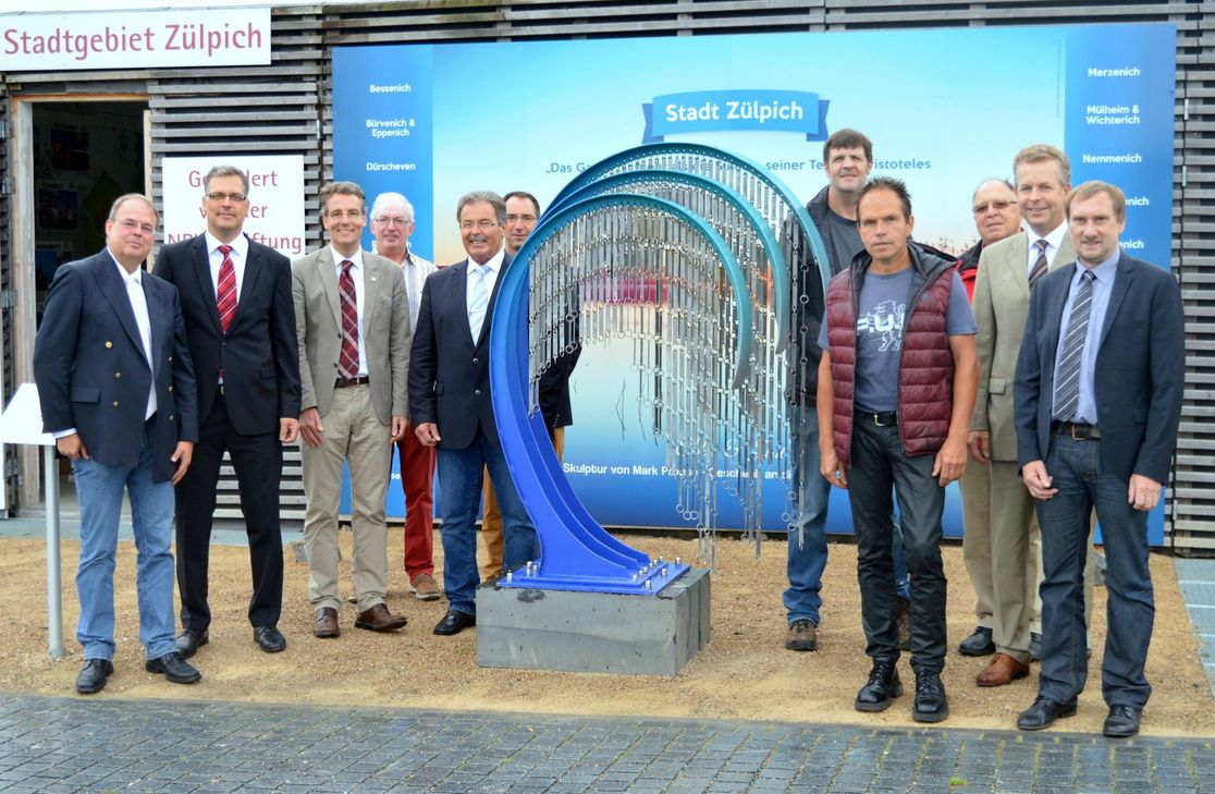 Über das neue Kunstwerk im Gartenschaupark Zülpich freuen sich (von links): Albert Stumm (Vorsitzender Förderverein Gartenschaupark Zülpich), Ulf Hürtgen (Bürgermeister der Stadt Zülpich), Christoph M. Hartmann (Geschäftsführer der Landesgartenschau Zülpich 2014 GmbH), Ernst Georg Fiege (Förderverein Gartenschaupark Zülpich), Franz Glasmacher (Ortsvorsteher Linzenich-Lövenich), Thomas Hellingrath (Prokurist Landesgartenschau Zülpich 2014 GmbH), Mark Prouse (Künstler), Jörg Schmitz (Baumschule Schmitz), Leo Wolter (Enzen), Dr. Peter Kramp (CEO Smurfit Kappa Zülpich Papier GmbH) und Ottmar Voigt (Beigeordneter der Stadt Zülpich).