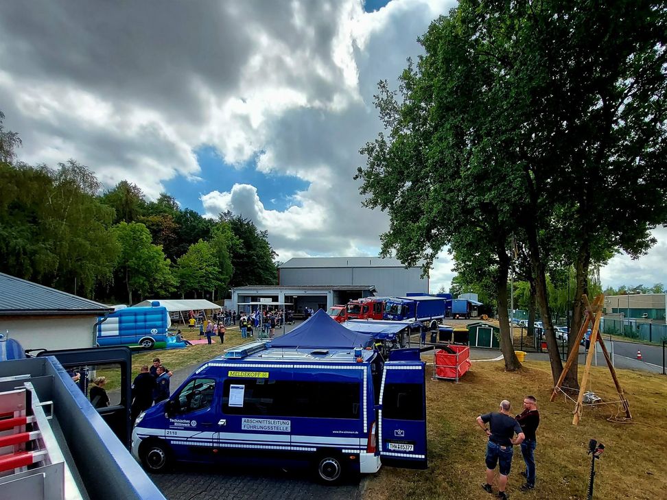 Blick über das Veranstaltungsgelände mit Fahrzeugausstellung und Kinderspielen.