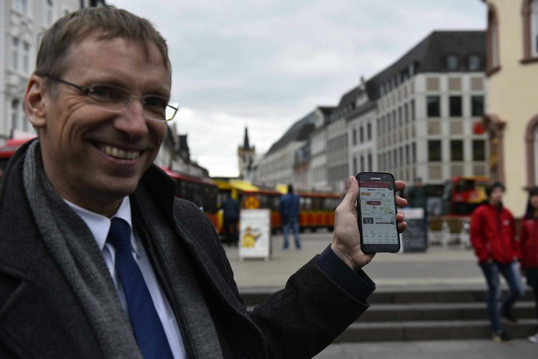 Norbert Käthler erklärt den Marx-Guide, mit dessen Hilfe Nutzer in das Trier des 19 Jahrhunderts reisen können. Foto: Alexander Schumitz/ Trier Tourismus und Marketing GmbH