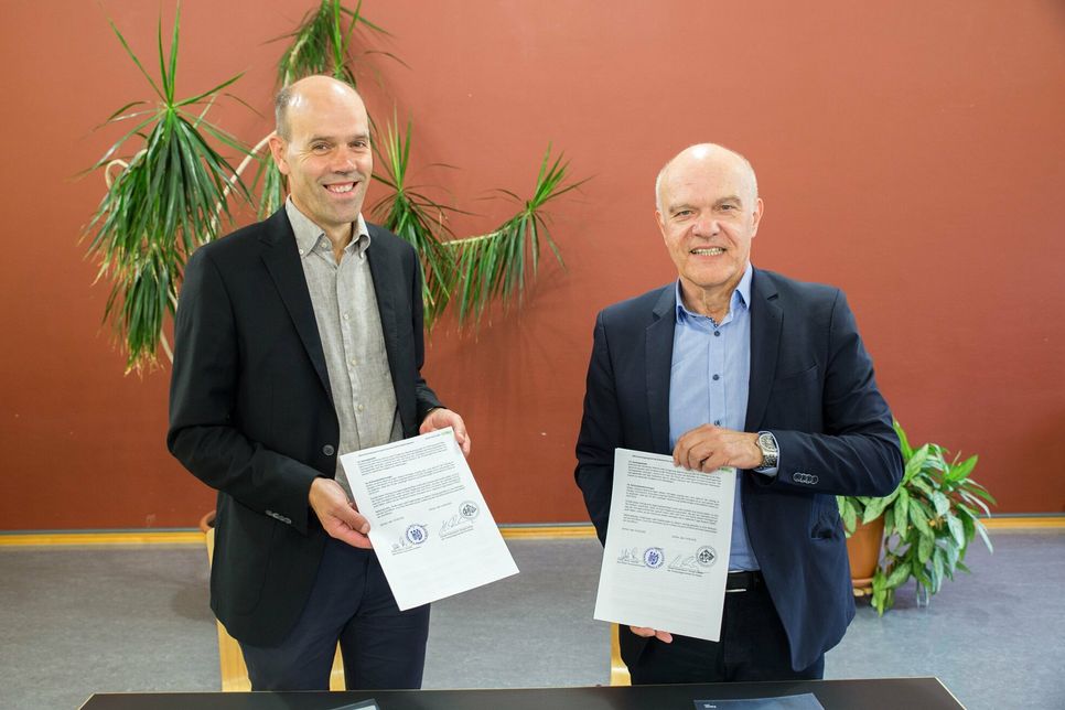 Landrat Volker Boch (links) und Bürgermeister Harald Rosenbaum mit dem unter-zeichneten Vertrag.