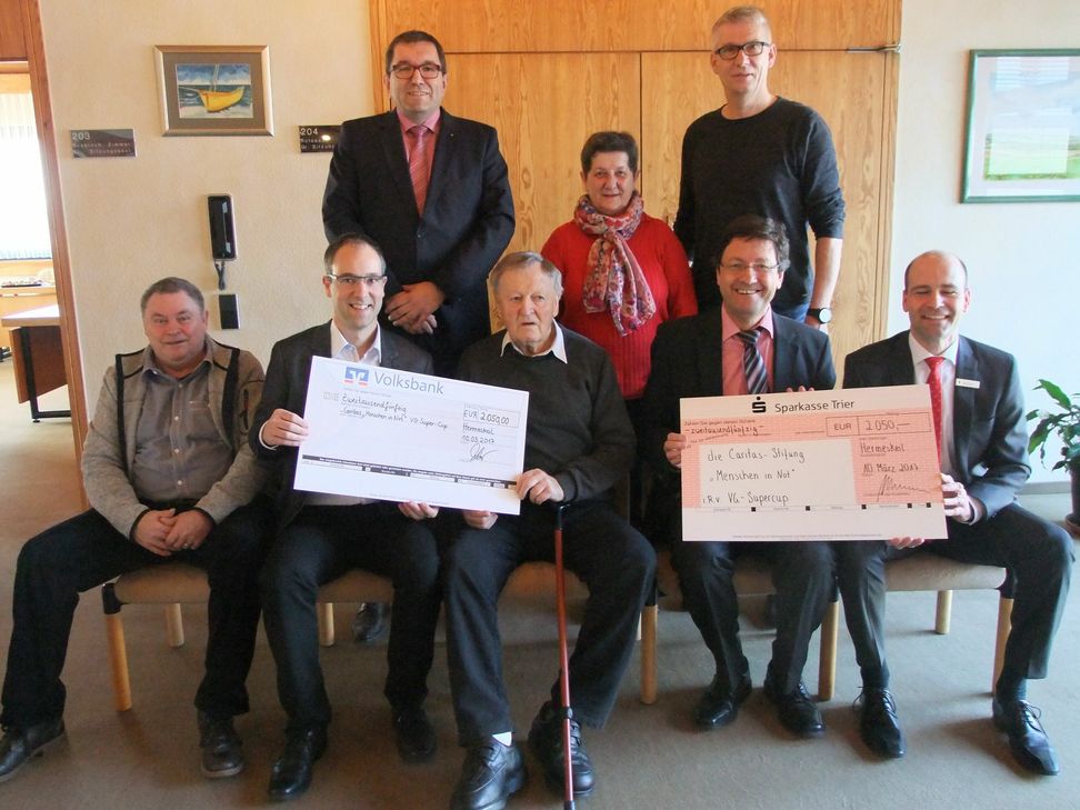 Scheck-Übergabe an Thomas Theis (vorn, Zweiter von links) von der Caritas-Stiftung Menschen in Not. Ab kommendem Jahr wird Hermann Meter (vorn, Mitte) beim Turnier aus Altersgründen nur noch beraten. Als möglicher Nachfolger ist Verbandsgemeindebürgermeister Michael Hülpes (vorn, Zweiter von rechts) im Gespräch. Foto: Fischer