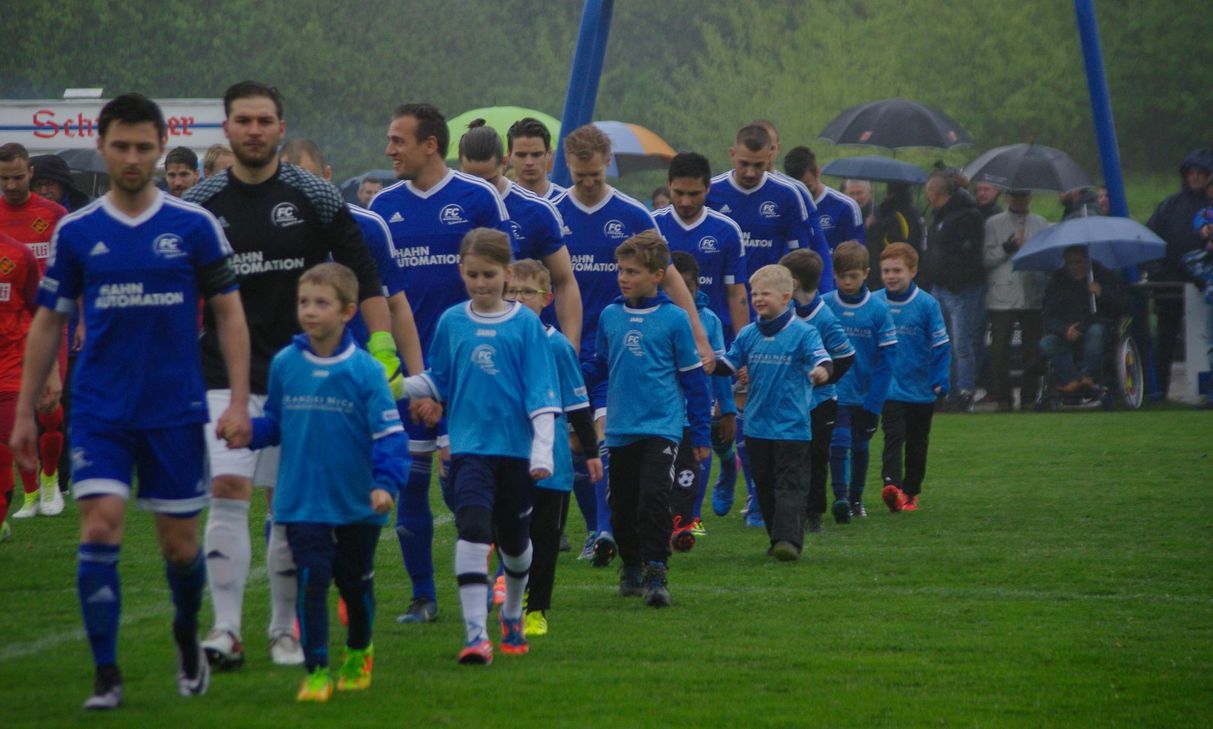 Dem Anlass angemessen lief der FC Karbach zum Pokal-Halbfinale mit seinen Jüngsten Mitgliedern als Begleitung auf. Am Ende wurde der Einzug in das Finale des Rheinlandpokals knapp verpasst. (Foto: Arno Boes)
