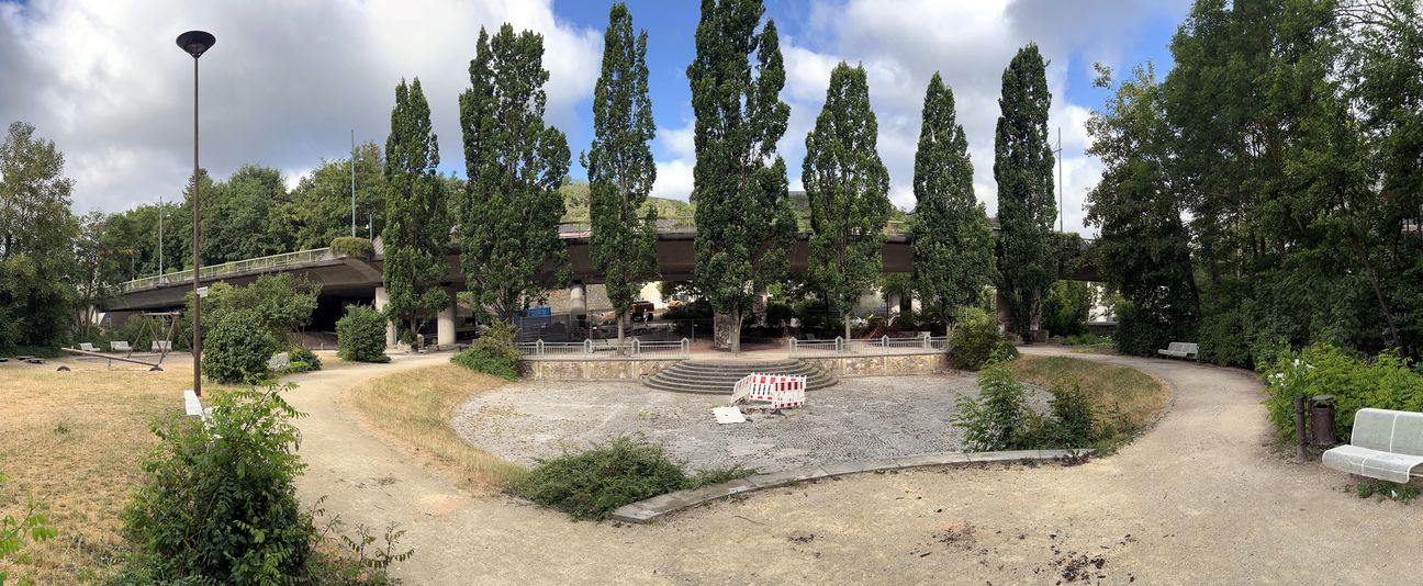 Der Helmut-Kohl-Europaplatz wird ab sofort klimagerecht umgestaltet. Die Arbeiten beginnen im Bereich des Idarbaches (rechter Bildrand), der Spielplatz (linker Bildrand) kann zunächst noch genutzt werden.