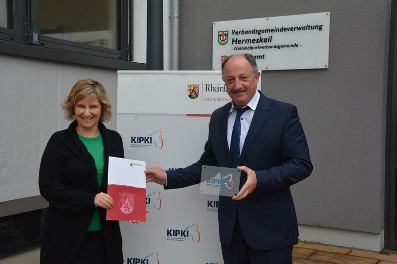 Klimaschutzministerin Katrin Eder überreicht einen Förderbescheid in Höhe von rund  454.000 Euro an Verbandsgemeinde-Bürgermeister Hartmut Heck.