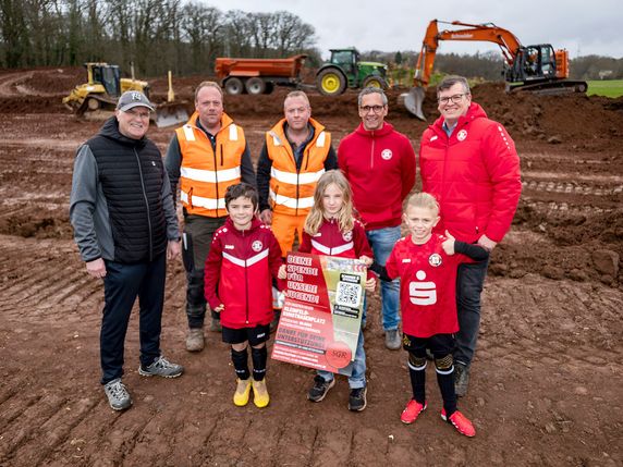 Freuen sich auf den neuen Kunstrasen in Glehn: Christof Marx von der Stadt Mechernich (v.l.), Tobias und Simon Esch vom Bauunternehmen Schneider, der zweite Vorsitzende Sandro Filipponi und der Geschäftsführer Markus Beul mit den Nachwuchskickern Michael (vorne v.l.), Paul und Leon aus der F-Jugend.