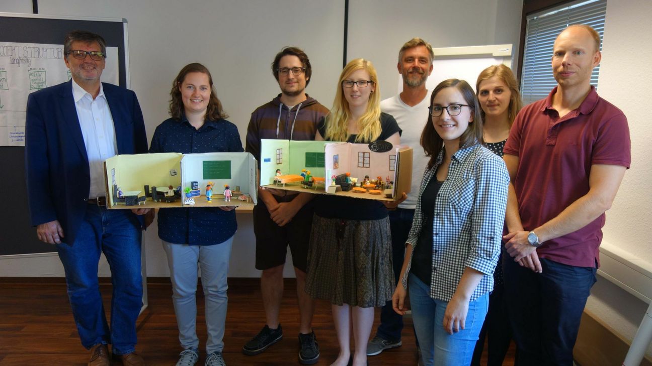 Die Studierenden Anne-Kathrin Schmitz, Andreas Lersch, Johanna Ginter, Martina Pokoj, Friederike Schütz (Mitte, v. l.) präsentierten gemeinsam mit den Seminarleitern Prof. Dr. Andreas Schröer (l.) und Thomas Wendt (r.) ihr neues Veranstaltungsformat Carsten Müller-Meine von der Ehrenamtsagentur Trier. Zur Veranschaulichung hatten sie ein Modell mit Playmobil-Figuren gebaut. Foto: Uni Trier