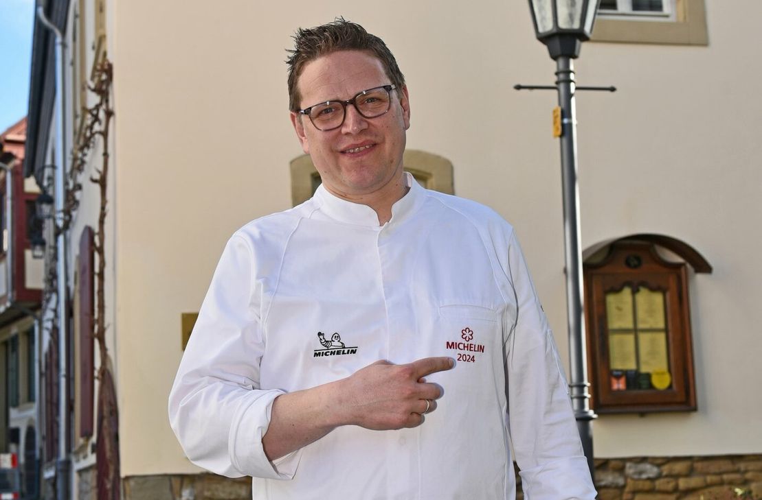 Stolz präsentiert Markus Pape den Michelin-Stern auf seiner neuen Kochjacke, die ihm bei der Michelin Guide Ceremony geschenkt wurde.
