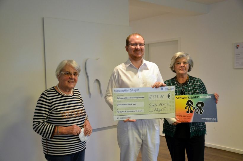 Zahnarzt Patrick Koch hat Zahngold seiner Patienten gesammelt und den Erlös von 8500 Euro an den Förderkreis schwerkranke Kinder e.V., vertreten durch Elke Henche und Gisela Esser, gespendet. Foto: T. Förster