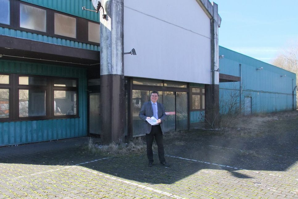 Stadtbürgermeister Dr. Mathias Queck vor der verfallenen Immobilie, die früher den Hela-Fachmarkt beherbergte. Das Gebäude soll nun abgerissen werden und Platz schaffen für  ein neues Einkaufszentrum. Foto: Fischer